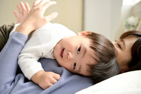 保護者の胸に寄りかかってくつろぐ赤ちゃん
